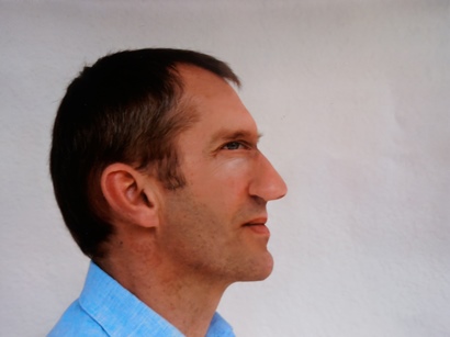 Das Profilbild eines Mannes mit blauem Hemd. 
